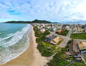 - une vue aérienne sur une plage avec des maisons dans l'établissement Pousada Olhos Verdes, à Bombinhas