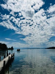 un lago con un molo e un cielo nuvoloso di Das Moosanger a Starnberg
