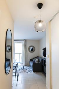 a living room with a blue couch and a mirror at Charmant studio en résidence avec parking in Bussy-Saint-Georges