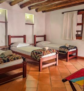 a room with three beds in a room at Hotel Casa El Mandarino By MH in Barichara