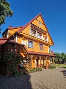 een groot houten huis met veel ramen bij pokoje wypoczynkowe "Róża" in Supraśl