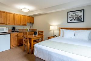 Habitación de hotel con cama y cocina en Sundance Lodge, en Sun Peaks