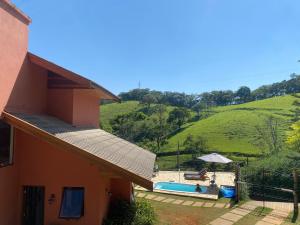 une maison avec piscine à côté d'une colline dans l'établissement Linda vista para as montanhas a 5 min da cidade, à Santo Antônio do Pinhal