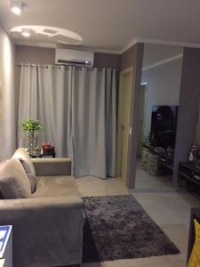 ein Wohnzimmer mit einem Sofa und einem Vorhang in der Unterkunft Yes Vancouver Flats in Corumbá
