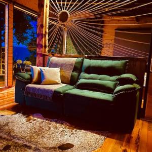 a green couch sitting in a living room at Pousada Flocos de Neve in Urubici