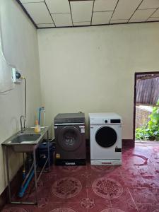 a room with a washing machine and a sink at Kai Lions International Hostel in Paksong