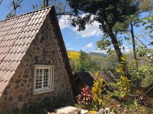 a small stone building with a window in a garden at Refugio Cariguana in Valle de Anton