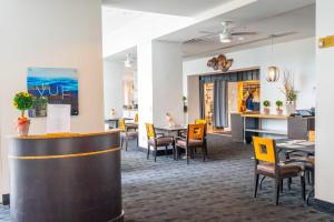 a restaurant with yellow chairs and tables and a bar at Luxury Condo Hotel with full kitchen, located at 5 mints walk to the beach in Fort Lauderdale
