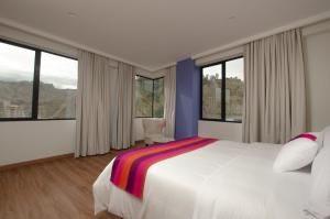a bedroom with a large white bed with windows at LAS BRISAS SUR in La Paz