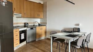 Cozy Apartment in La Tejita في غراناديا دي أبونا: مطبخ مع طاولة وكراسي وثلاجة
