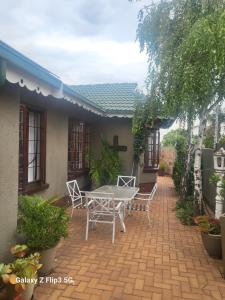 a patio with a table and chairs in front of a house at Lotus 5a in Brakpan