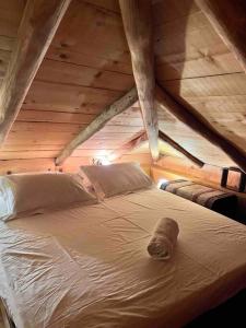 a bed in a attic with a wooden ceiling at Magical cottage! in Agios Georgios Nilias