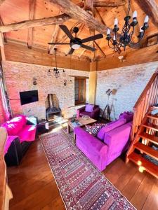 a living room with purple furniture and a brick wall at Magical cottage! in Agios Georgios Nilias