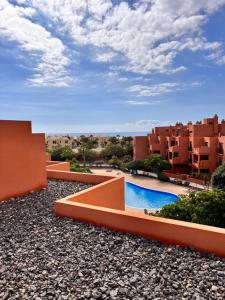 格拉納迪利亞德阿沃納的住宿－Cozy Apartment in La Tejita，从公寓的阳台可欣赏到游泳池的景色