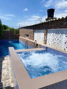 uma grande piscina num edifício de tijolos com em Cabaña Villa Roma em Santa Marta
