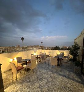 a patio with tables and chairs on a roof at Pyramids Pride Inn in Cairo
