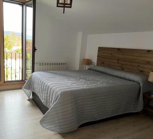 1 dormitorio con cama y ventana grande en A PORTELA - Pereiro de Aguiar, en Covas