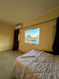 a bedroom with a large bed and a window at Pyramids Pride Inn in Cairo