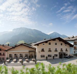 um grupo de edifícios com montanhas ao fundo em Hotel Metzgerwirt em Sankt Veit im Pongau