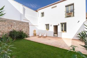 un patio de una casa blanca con 2 sillas en Casa Alhambra einzigartiges Haus bei Granada, en Dúrcal