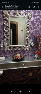 Baño con espejo en una pared púrpura en Apartamento El Rincón de Pilar, en El Astillero