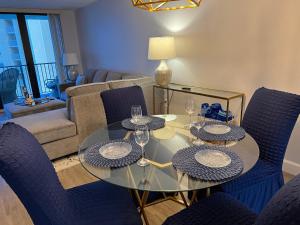 a dining room with a glass table and blue chairs at Coastal Condo on the beach at Ocean Trillium #501 in New Smyrna Beach