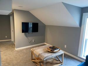 a living room with a table and a tv on the wall at Miracle House in Anoka