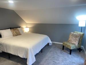 a bedroom with a large bed and a chair at Miracle House in Anoka