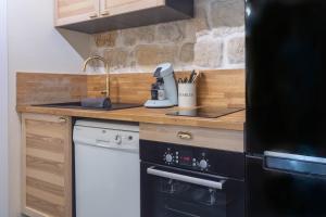 a small kitchen with a sink and a stove at Incroyable appartement Parisien in Paris