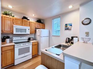 - une cuisine avec des appareils blancs et des armoires en bois dans l'établissement Lovely Family Townhome in Great Location-2200SCD townhouse, à Kissimmee