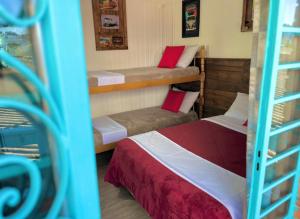 a room with two beds and two bunk beds at Casa do Rogério Hostel in Caxias do Sul