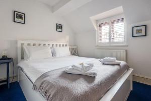 a bedroom with a white bed with towels on it at Cosy 2-Bedroom Haven in Picturesque Headington in Oxford