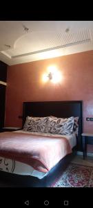een slaapkamer met een bed met een bruine muur bij Appartement abdessalam fetouaki in Moulay Yacoub