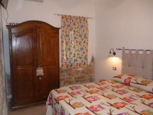 1 dormitorio con 1 cama y armario de madera en B&B La Taverna dei Ciucci en Foce del Sele