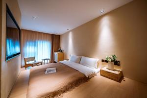Qingdu - LiYuan Hotel في دالي: غرفه فندقيه سرير كبير وتلفزيون