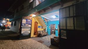 a building with the doors open on a street at night at Hostal Dulces Sueños in Panajachel