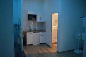 Eaux Spa في رووين: مطبخ فيه دواليب بيضاء وحائط ازرق