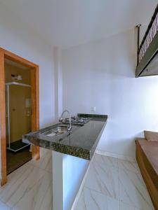 une cuisine avec un comptoir en granit dans une pièce dans l'établissement Casa Loft para temporada Guarapari, à Guarapari