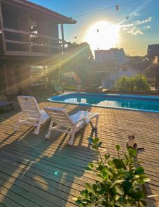 a patio with two chairs and a swimming pool at Casa do Rogério Hostel in Caxias do Sul