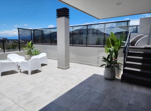 un patio con muebles blancos en el techo en Amapola's II en Salta