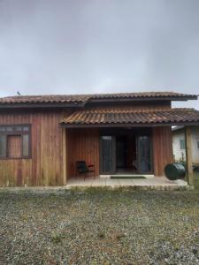 ein kleines Haus mit einer Veranda und einer Terrasse in der Unterkunft Casa de Veraneio em São Francisco do Sul - Praia do Ervino in São Francisco do Sul