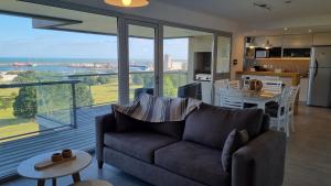 sala de estar con sofá y cocina con vistas. en Piso Premium Vistas Mar & Golf en Mar del Plata