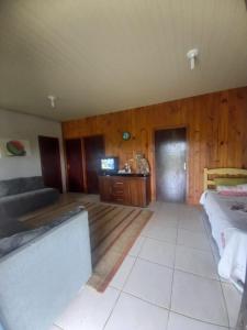 Zimmer mit einem Bett, einem Sofa und einem Tisch in der Unterkunft Casa de Veraneio em São Francisco do Sul - Praia do Ervino in São Francisco do Sul