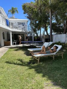 a woman laying on a lounge chair in the grass at CALI Backpackers in Caloundra