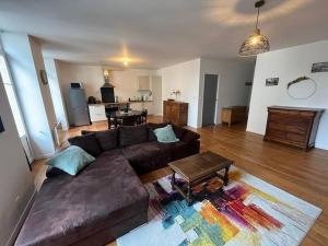 sala de estar con sofá marrón y mesa en Appartement en cœur de ville, en Mauléon-Licharre