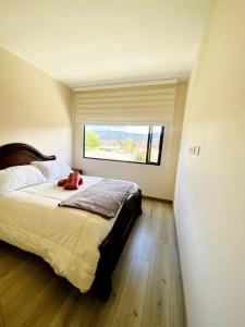 Un dormitorio con una cama grande y una ventana en Moderno Alojamiento Calle 100, en Bogotá