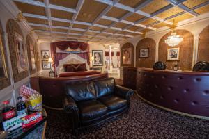 a living room with a leather chair and a bed at The Anniversary Inn - Boise in Boise