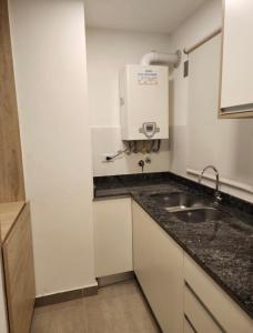 een kleine keuken met een wastafel en een boiler bij Amapola's II in Salta