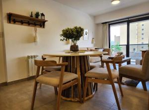 een eetkamer met een tafel en stoelen en een raam bij Amapola's II in Salta