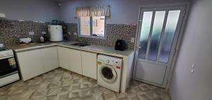 a kitchen with a washing machine and a washer at La Bicicleta in Aldea Camarero